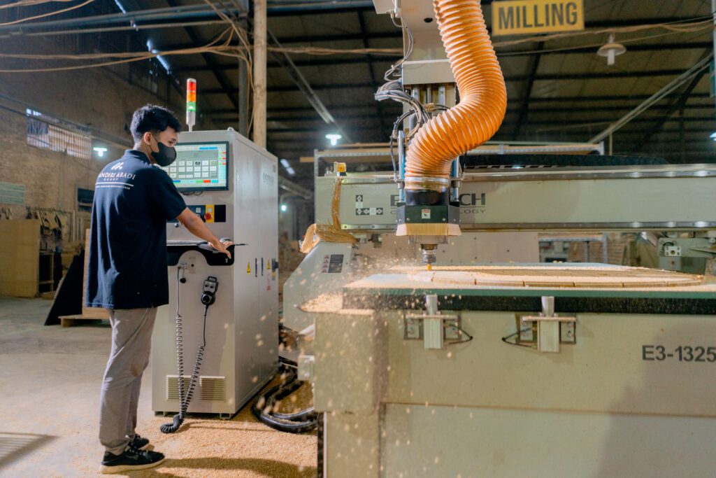 Mitarbeiter bedient eine CNC-Bearbeitungsanlage in einem Fertigungsbetrieb