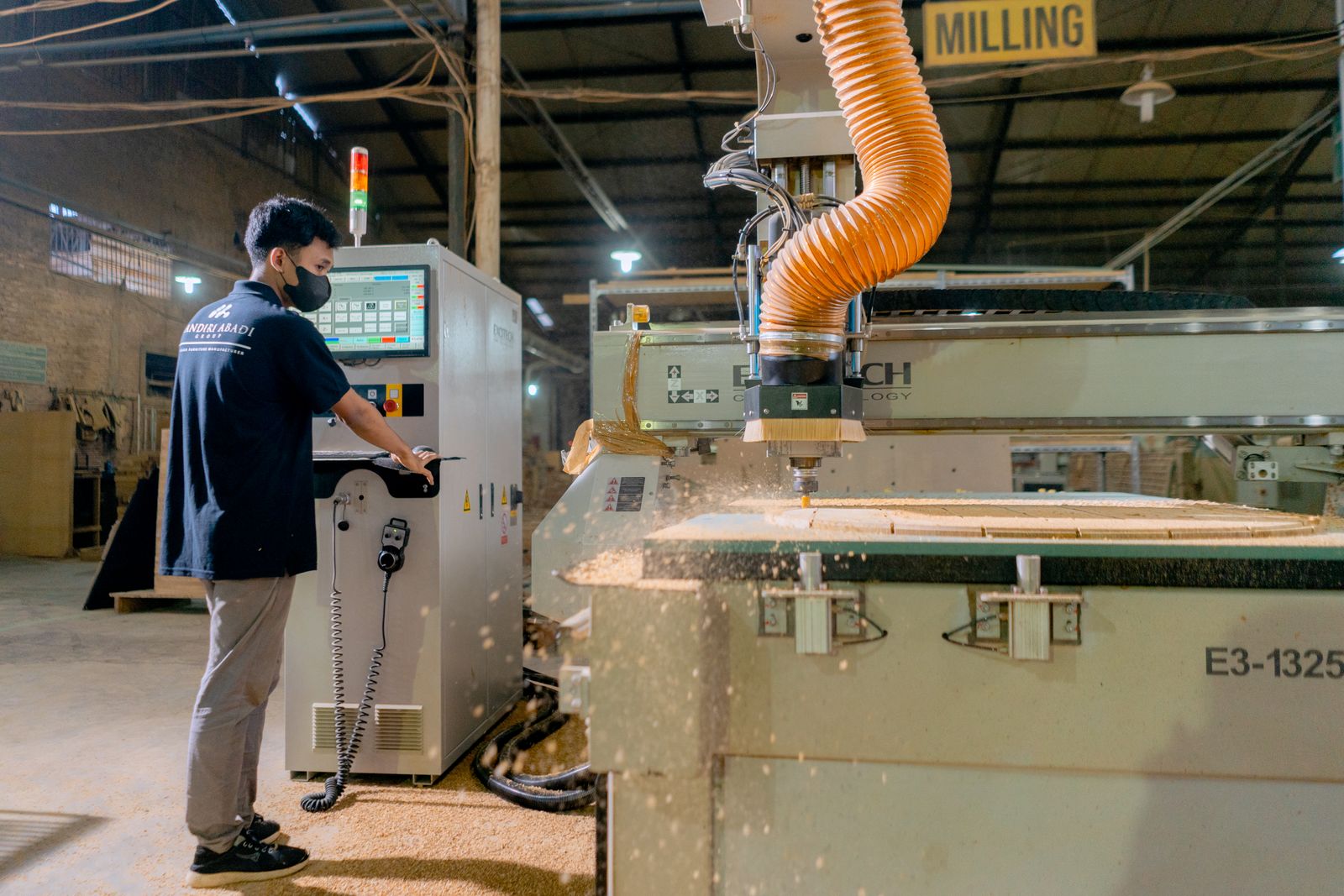 Mitarbeiter bedient eine CNC-Bearbeitungsanlage in einem Fertigungsbetrieb